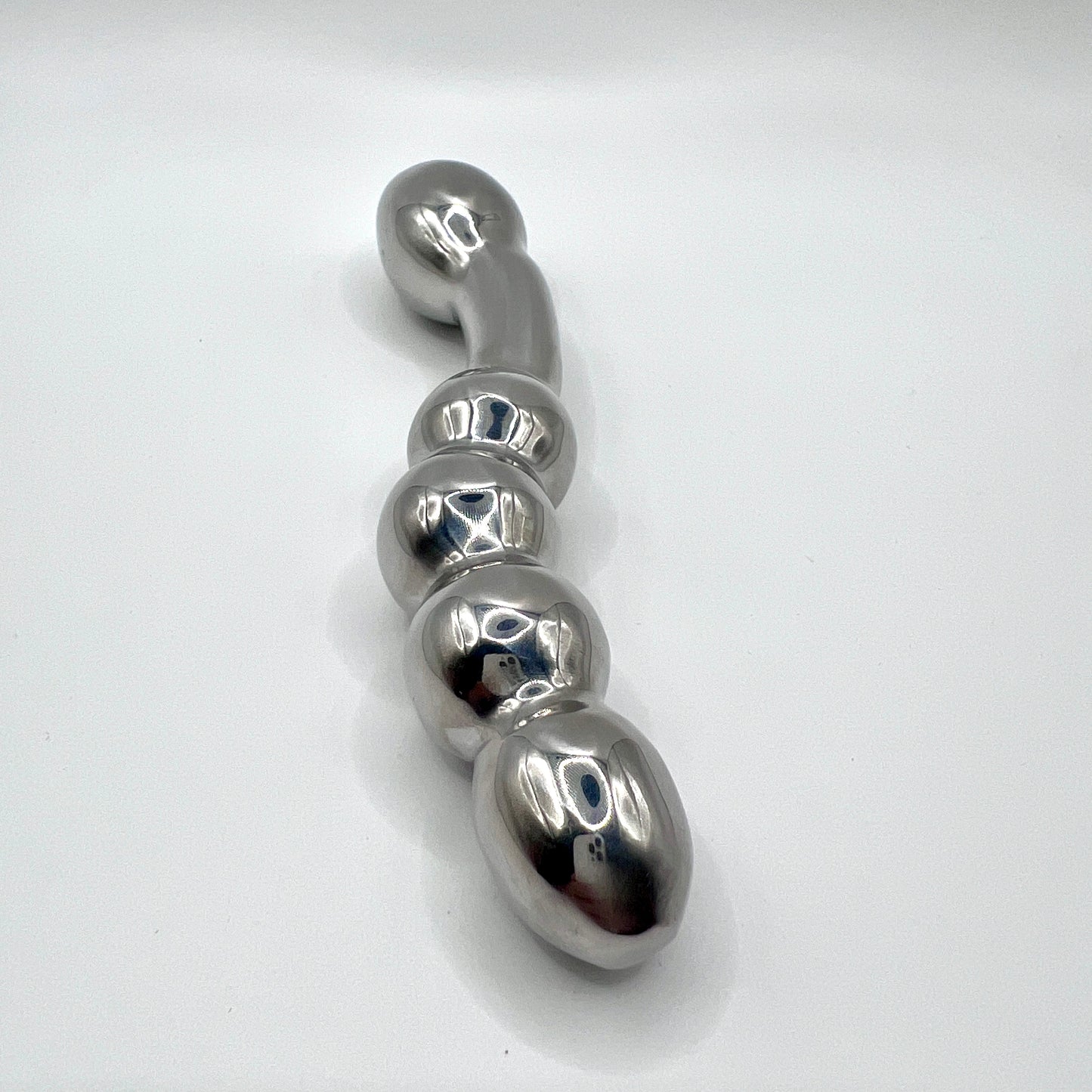 Metallic object with a series of rounded, oval shapes on a white background