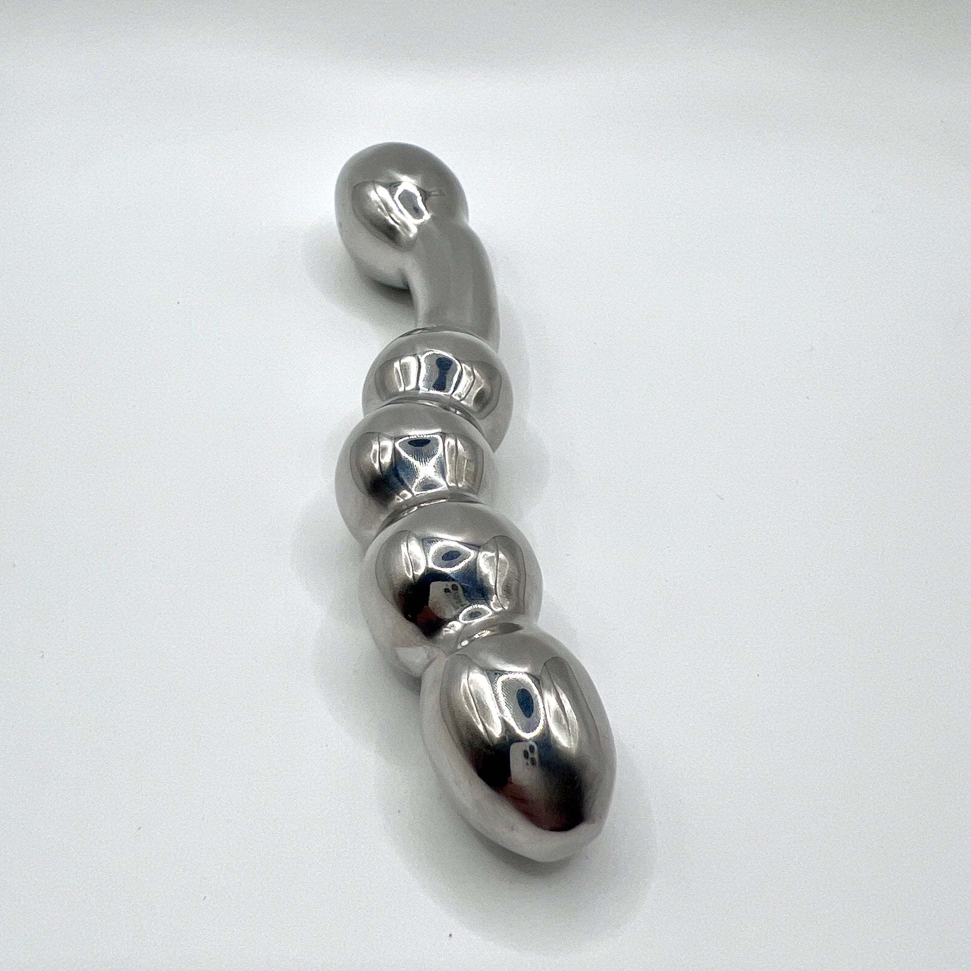 Metallic object with a series of rounded, oval shapes on a white background