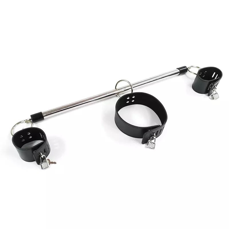 A metal and black restraint set featuring a long silver bar, a black collar, and two black cuffs with small silver padlocks and keys, photographed on a plain white background.