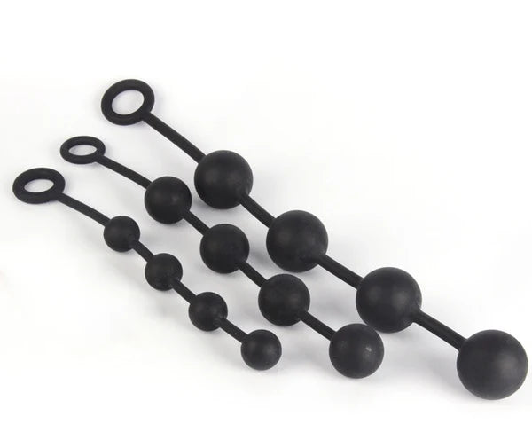 Three black silicone butt plugs with varying bead sizes and looped ends, arranged diagonally on a plain white background.